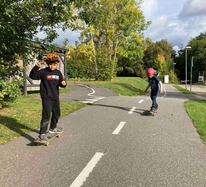To elever på skateboards på stien